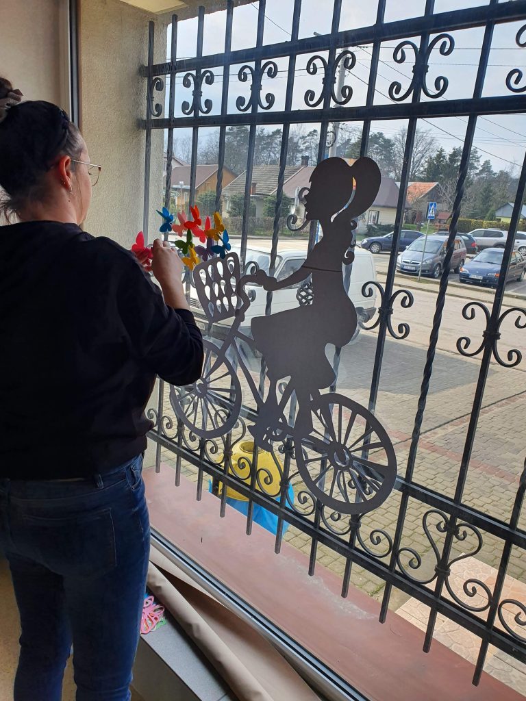 kobieta malująca na oknie