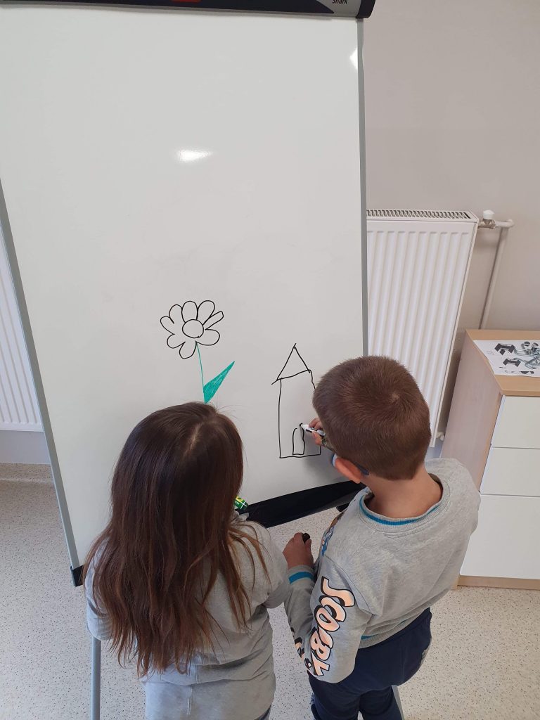 dzieci rysujące na tablicy